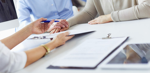 Doctor in clinic asking senior woman in wheelchair for a signature