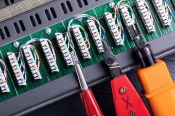 Different types of punch down tool with a blade closeup on an open cat5e ethernet patch panel...
