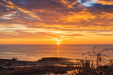 Early sunrise and epic cloudy sky at rocky seashore coast of Torrevieja, Alicante, Spain. Mediterranean sea 2019