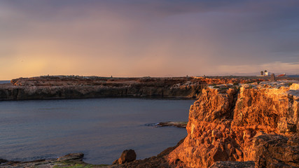 Early sunrise and epic cloudy sky at rocky seashore coast of Torrevieja, Alicante, Spain. Mediterranean sea 2019