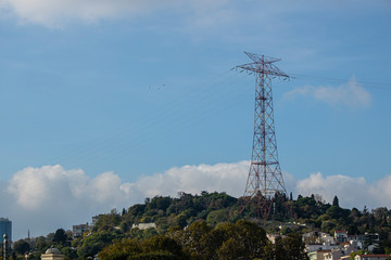 The high tension line appears among the trees. Blue sky in the background.