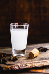 Ouzo or Uzo, is a Greek anise brandy, traditional strong alcoholic drink in glasses on the old wooden table. Greek tradition, drink of the gods. Place for text