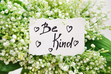 Be kind - calligraphy lettering with hearts in white flowers, motivation phrase about goodness