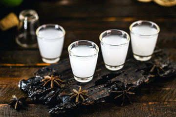 Traditional arabic alcohol drinks Raki with anise, rustic wooden background with space for text.