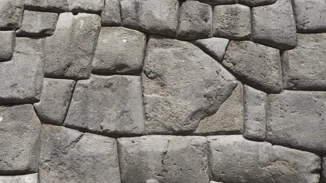 Ancient citadel defensive walls at Inca fortress ruins of Sacsayhuaman, Cusco, Peru. Detail of traditional Inca architecture and construction with huge stone blocks carved and rounded to fit perfectly