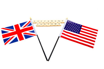 The flags of the United Kingdom and the United States isolated on a white background with a sign reading Different Customs