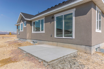 Construction outside a home with flat concrete surface surrounded by soil
