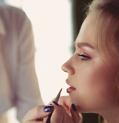 beautiful young model woman getting fashion make-up