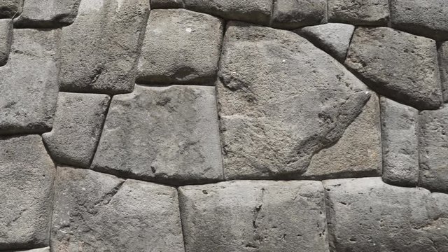 Ancient fortress defensive walls at Inca citadel ruins of Sacsayhuaman, Cusco, Peru. Detail of traditional Inca architecture and construction with huge stone blocks carved and rounded to fit perfectly