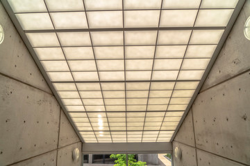 Slanted glass roof of building with concrete side wall and clear glass wall