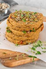 Raw veggie burger with lentils, vegetables and thyme leaves on kitchen countertop.