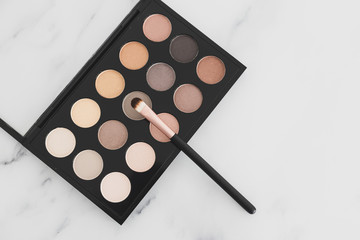 beauty industry and make-up products, eyeshadow palettes with nudes and bronzy tones with brushes