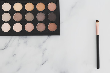 beauty industry and make-up products, eyeshadow palettes with nudes and bronzy tones with brushes