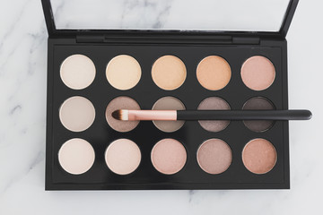 beauty industry and make-up products, eyeshadow palettes with nudes and bronzy tones with brushes