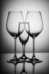 Three empty glasses on a table with gray backlight