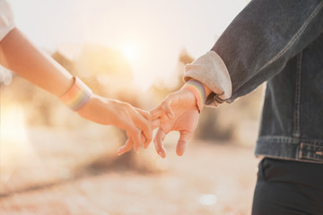 Cropped shot of women LGBT lesbian couple holding hands with rainbow pride. LGBT equal rights...