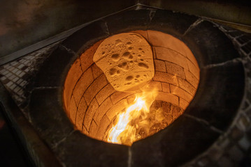 Bread in the Traditional Tandouri Oven. fresh and scorching tandir in a traditional oven. - obrazy, fototapety, plakaty