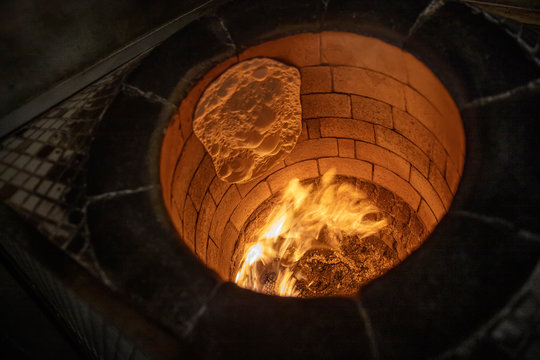 Bread in the Traditional Tandouri Oven. fresh and scorching tandir in a traditional oven.