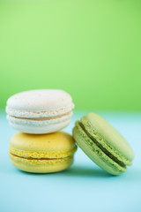 Colorful macarons on green and blue background