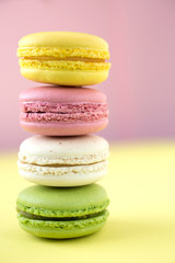 Colorful macarons on pink and yellow background