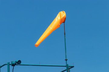 orange wind sock blowing in the sunlight in springtime
