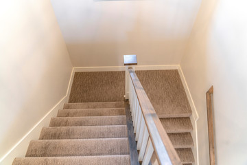 U shaped staircase with handrails and gray carpet inside a home with white wall