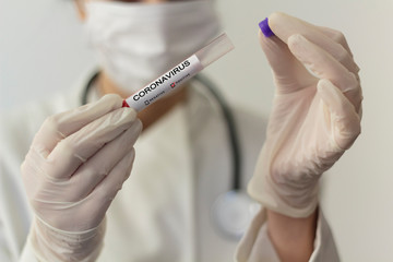 Nurse or doctor with face mask holding blood test with positive result for Coronavirus 2019-nCoV