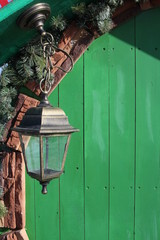 decorative brass street lamp for lighting hanging on a bracket at the door at the entrance