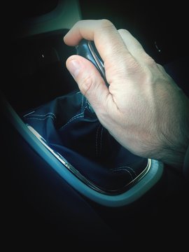 Close-Up Of Hand Holding Gearstick In Car