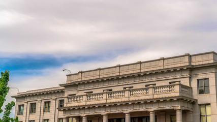 Panorama Building with white wall balcony and security camera on roof against cloudy sky