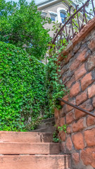Fototapeta na wymiar Vertical frame Close up of outdoor stairs amid stone brick retaining walls that leads to a home