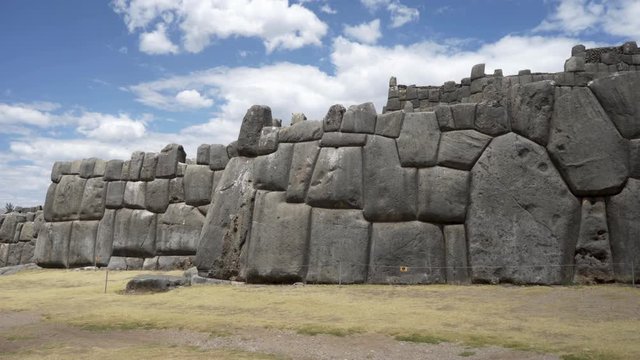 Ancient Inca citadel defensive walls at fortress ruins of Sacsayhuaman, Cusco, Peru made of huge stone blocks carved and rounded. Traditional Inca architecture and construction.