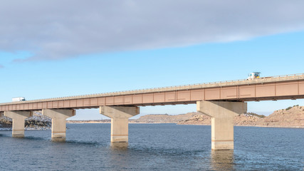 Panorama Bridge across a lake with scenic view of hills and cloudy blue sky in winter