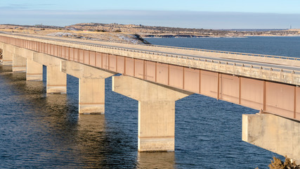 Panorama Beam bridge with deck supported by abutments or piers spanning over blue lake