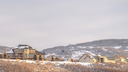 Panorama Houses on residential area nestled on hills blanketed with snow in winter
