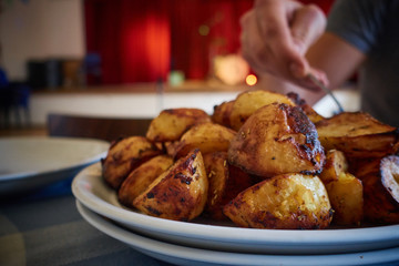 Close up of British Roast Potatoes in a church hall with drums on the stage in the background. Space for Text.