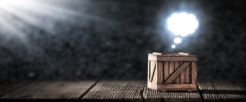 "Think Outside The Box" Concept - Old Wooden Box On Table With Bright Glowing Thought Cloud Above