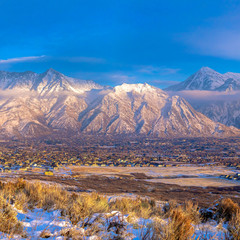 Square Panoramic view of Mount Timpanogos and residences blanketed with snow in winter