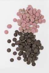 Confectionery dark and strawberry (pink) chocolate in dragee on a white background