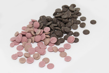 Confectionery dark and strawberry (pink) chocolate in dragee on a white background