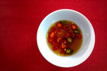 Spicy Red Chili Sauce in white bowl kept on red table at Bangkok Thailand