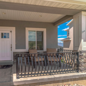 Square frame Home facade with porch chairs against window and front door with glass panes