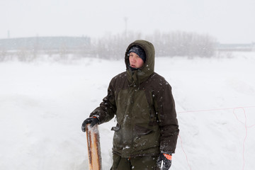 Worker in winter overalls with a board in his hand