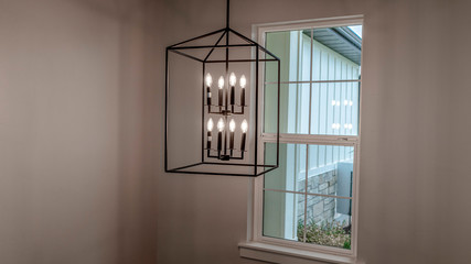 Photo Panorama Geometric chandelier hanging from the ceiling of home against window and wall