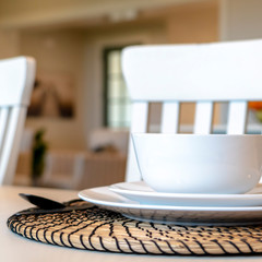 Square frame Table setting on family dining table with white tableware and round placemat