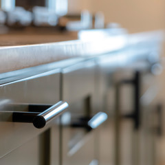 Photo Square frame Wooden cabinet with black handles and drawers inside the kitchen of home