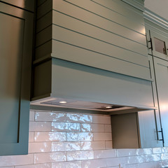 Square frame Kitchen interior with hanging cabinets against tile backsplash and ceiling