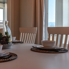 Square frame Table setting at the dining room of home against window and glass door