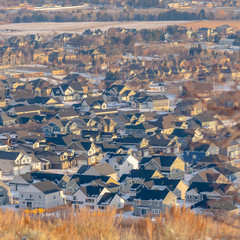 Obraz premium Photo Square frame Neighborhood landscape nestled amid hilly terrain blanketed with snow in winter