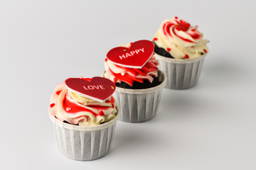 St. Valentine's Day background for bakery, confectionery. Three cupcakes with labels for Valentine's day on a white background.